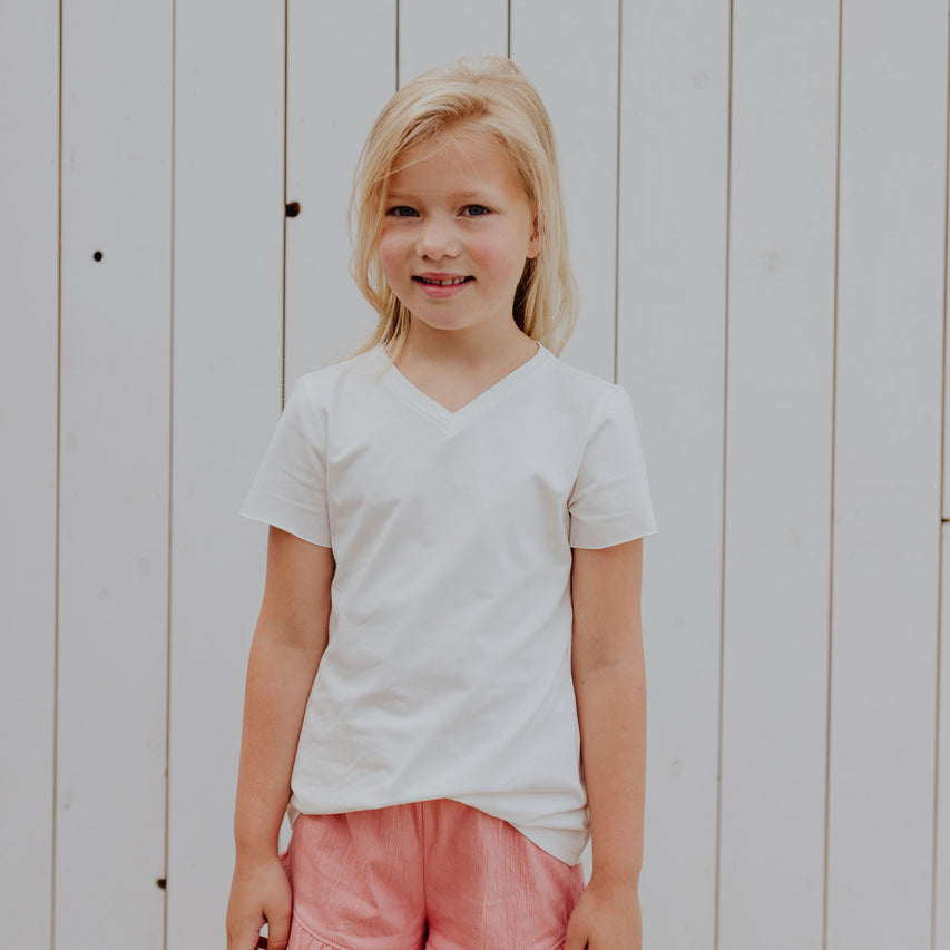 Little Hedonist ruffled short in Coral Almond for girls. Made from organic soft muslin. Sustainable kids clothing.
