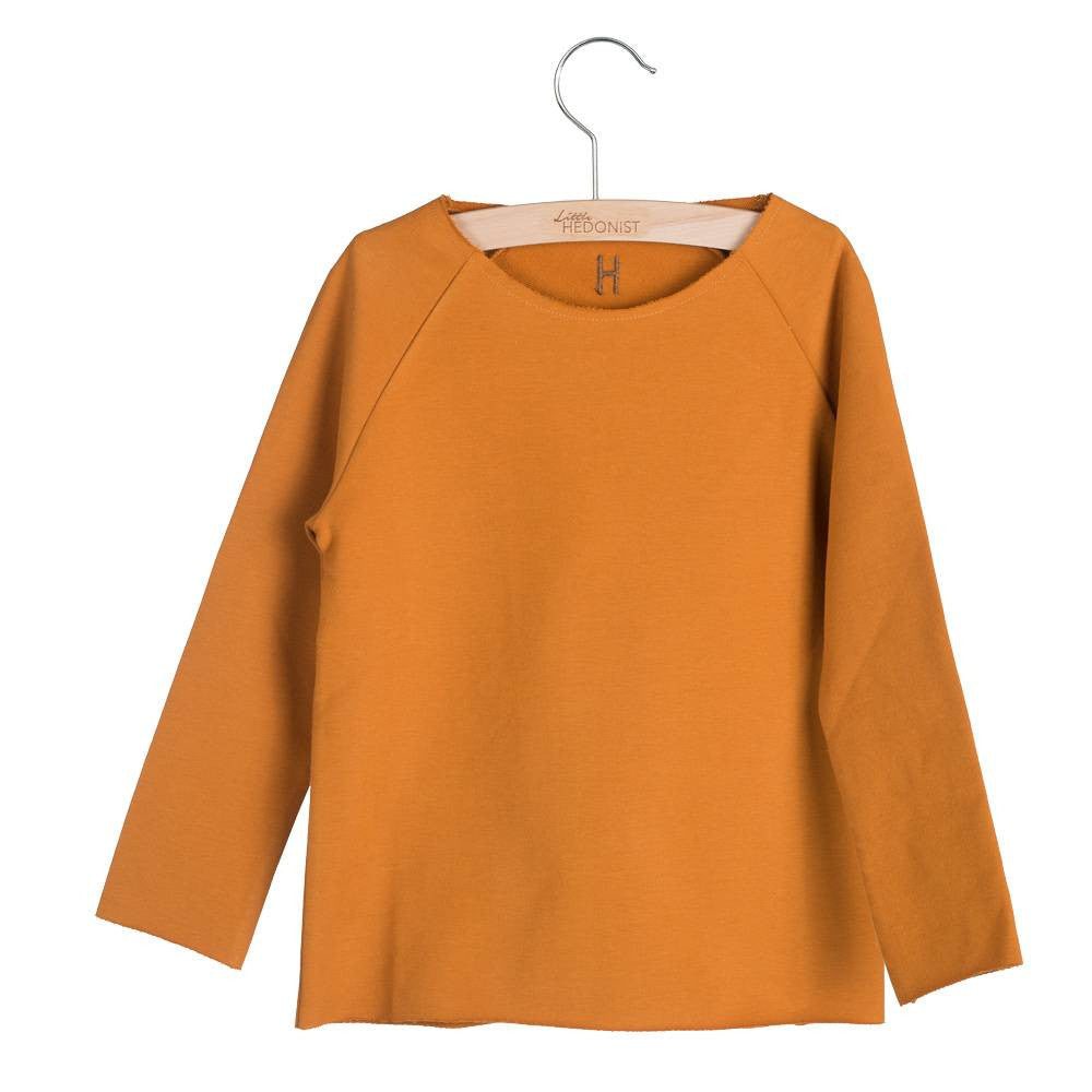 The wide neckline of this jersey with raglan sleeves is made to dress easy. It is all raw edged, only the neckline has a stich so it wont get even wider when wearing it. Little Hedonist