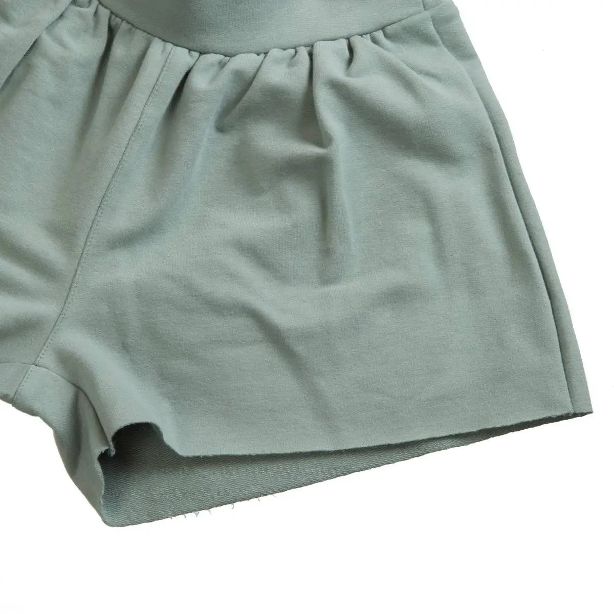 Little Hedonist organic pleated shorts with flowing cut and hidden pockets in Chinois Green. Sustainable fashion for kids.